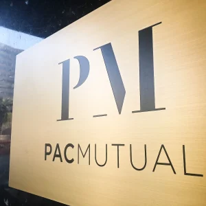 a high end looking sign panel with black letters and logo on brushed gold background