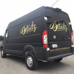 A black van with logo graphics on the side an rear.